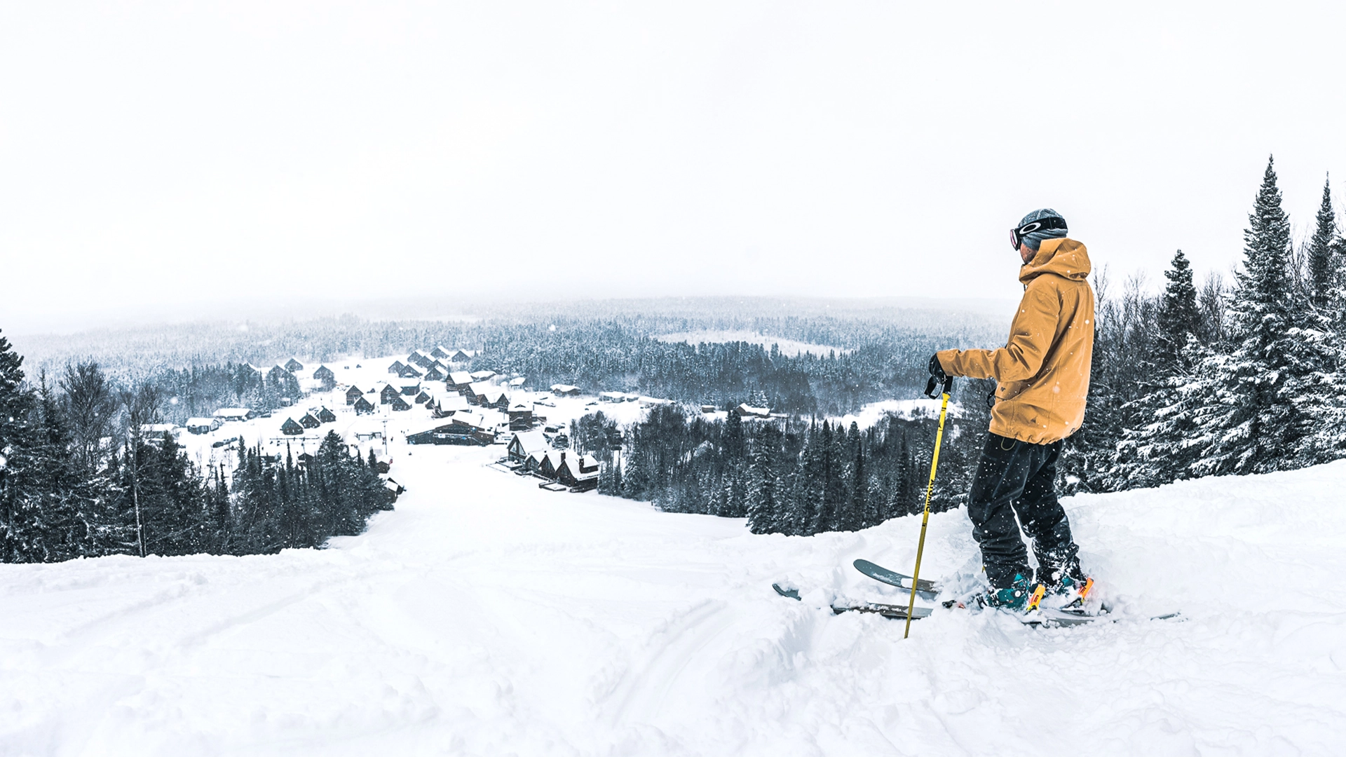 Un skieur observe le village alpin du Mont-Vidéo du haut des pentes