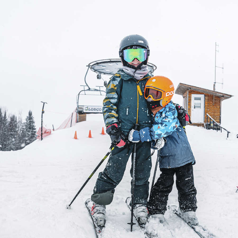 Deux enfants à skis prennent la pose