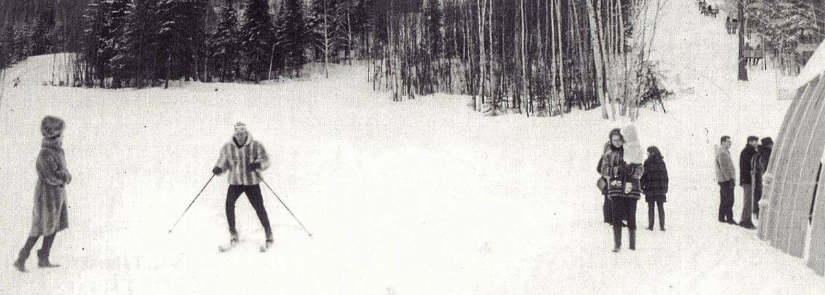 Image d'archives en noir et blanc de skieurs au pied de la montage avec des manteaux de fourrures